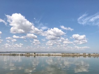 летний морской пейзаж. белые облака отражаются в море