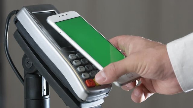 Close-up view of person using contactless payment with nfc techology. Smartphone with green screen template
