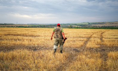 Hunter moving with shotgun looking for prey.