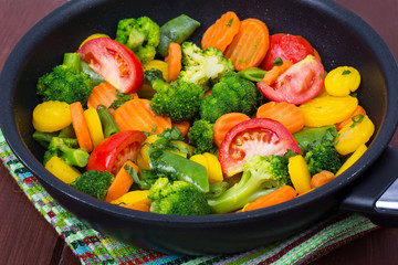 Carrots, broccoli, tomatoes  in  frying pan. Vegetarian menu