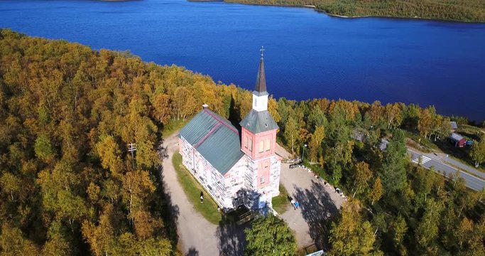 Arctic church, Cinema 4k aerial view around utsjoki church, revealing mantojarvi lake and utsjoki town, in Lapland, on a sunny autumn day, in Lappi, Finland