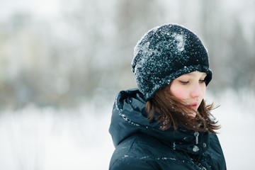 The girl in the black hat looks down.