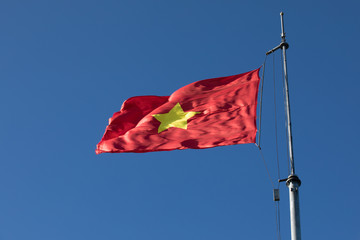 vietnam flag on top pole against beautiful clear blue sky