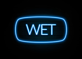 Wet  - colorful Neon Sign on brickwall