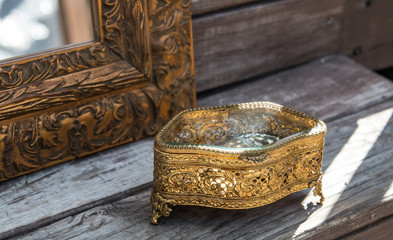 Golden table decoration idea - tray, mirror in gold frame, porcelain tea cup, jewelry box