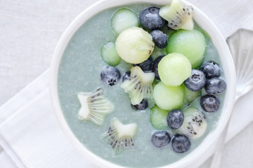 Blue spirulina smoothie bowl with melon, kiwi fruit and blueberries