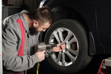 mechanic preparing to change the tire on car 