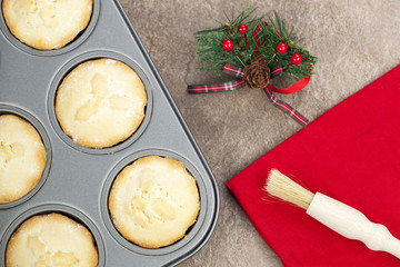 Fresh mince pies in a baking tray with a christmas motif