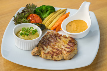 Barbecue pork steak on plate served with mashed potato and vegetables