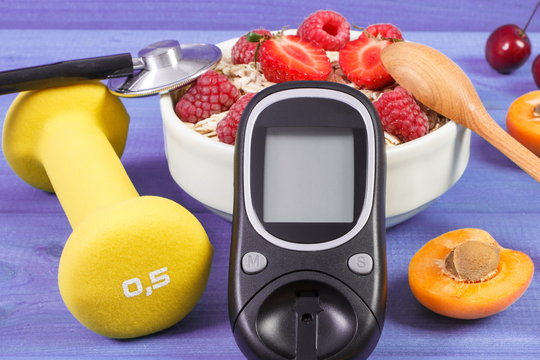 Glucose meter, fresh oatmeal with fruits and dumbbells, concept of checking sugar level during diabetes