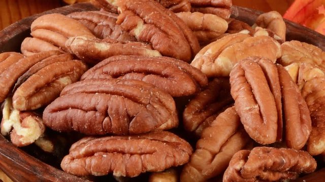 Zoom out shot of a bowl of pecans on a holiday table