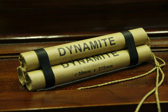Dynamite stick isolated on wooden table
