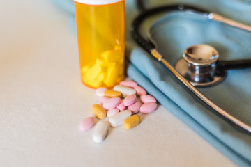 Medicine (pills), pill bottle, vitamins, stethoscope and scrubs background