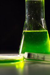 Beaker and retort with green and blue with a chemical reagent. Chemical experiment with Laboratory...