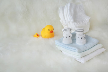 Collection of items for newborn babies on white fur.