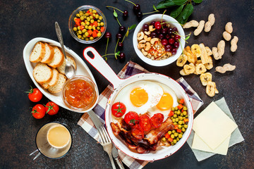 Breakfast including coffee, fried egg , becon. nut , muesli and bread . Top view
