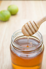 Honey dipper in glass jar.