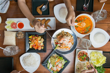 Top view of people eating Thai food together.