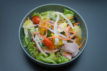 Top view of vegetable salad with ham, crab stick, apple and corn.