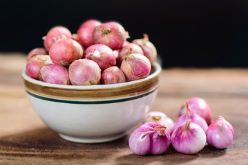 Fresh shallots in a bowl and wooden background, spice and herb, food ingredient