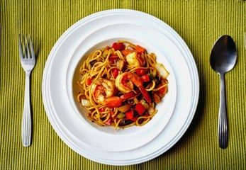 Spaghetti with Thai Spicy Herbal Sauce and prawns on white plate