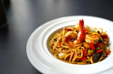 Spaghetti with Thai Spicy Herbal Sauce and prawns on white plate