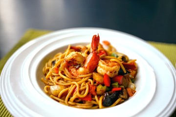 Spaghetti with Thai Spicy Herbal Sauce and prawns on white plate