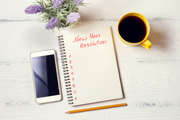 Red inscription "New Year Resolution"  in notebook on white desk