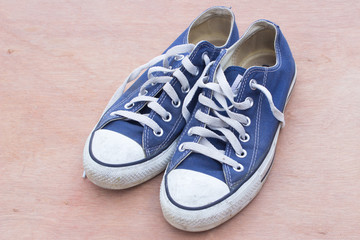 pars of canvas  blue shoes on the wood background , dirty blue shoes