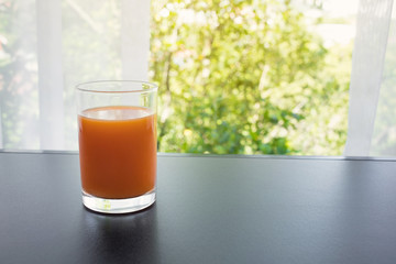 Close up orange juice glass in morning with window view.Healthy drink concepts