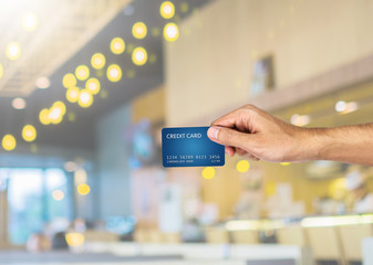 Credit card hand holding with blurred restaurant background