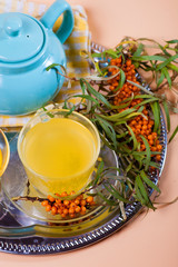 Tea made from sea buckthorn berries healthy for health delicious, saturated with vitamins surrounded by berries and sea buckthorn leaves for family tea drinking and maintaining health in the body