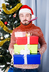 Man on holiday in hat and whistle with gifts