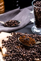 Coffee poured into an ancient antique silverware spoon. Around the spoons scattered coffee beans.