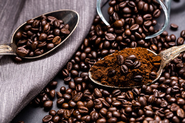 Coffee poured into an ancient antique silverware spoon. Around the spoons scattered coffee beans.