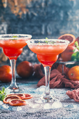 Blood Orange Margarita cocktail with mint and red orange in salt rimmed cocktail glass with tequila