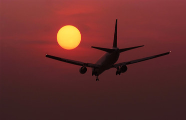Fototapeta na wymiar Plane, landing, red sunset travel