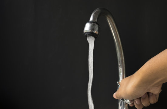 hand turning off water valve in concept saving water for future