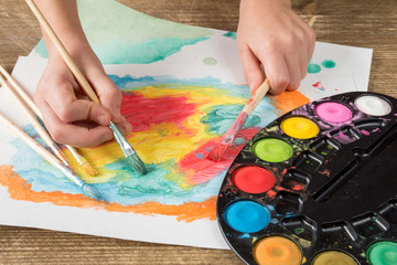 Naklejka premium Child painting with paintbrush