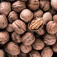 Walnut kernels and whole walnuts on rustic old wooden table