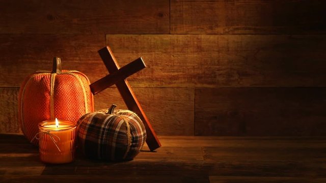 This is a close-up video symbolizing Thanksgiving, fall, autumn, using a still life embroidered Pumpkin setting inside a barn background made up of old red wood.
