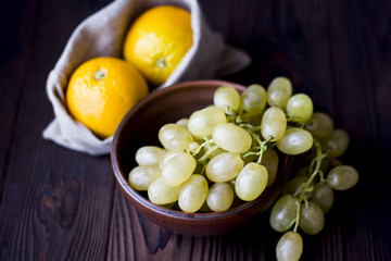 oranges and grapes on wooden background