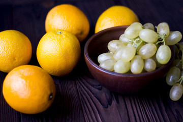 oranges and grapes on wooden background