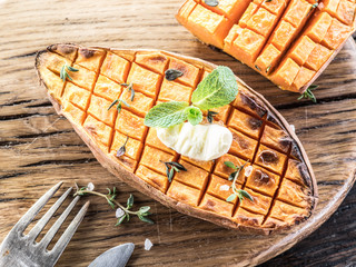 Baked batata on the old wooden table.