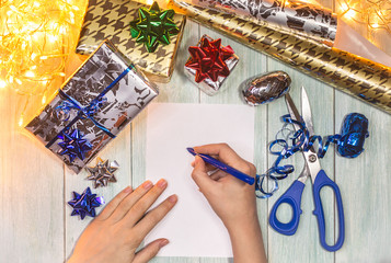 Christmas composition with gifts, hands writing a letter