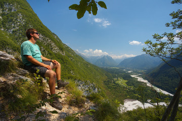 Naklejka premium Resting man watching a valley of Soca river, Triglav NAtional Park, Slovenia