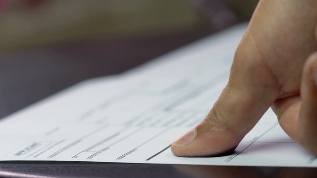 A man is being finger printed for either a crime  on a legal document form, Dolly shot
