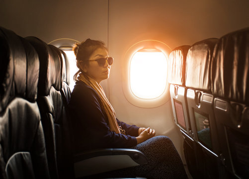 Lonely Asian Woman Sitting Beside Plane Window Use For Traveling Theme