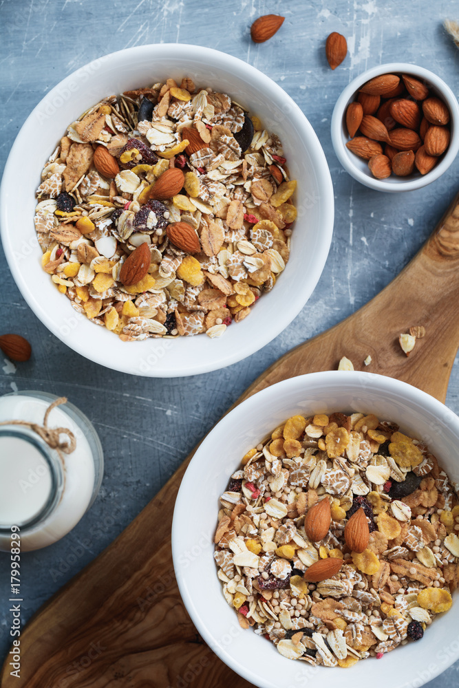 Wall mural top view of the breakfast for two person with muesli with almond nuts and dried berries in white bow