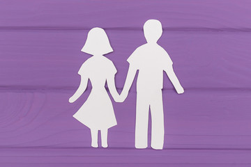 Paper silhouette of man and woman holding hands